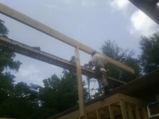 Carpenter setting a ridge beam over a new addition frame — Ice Dam Removal by Roofing Brothers in Yankeetown